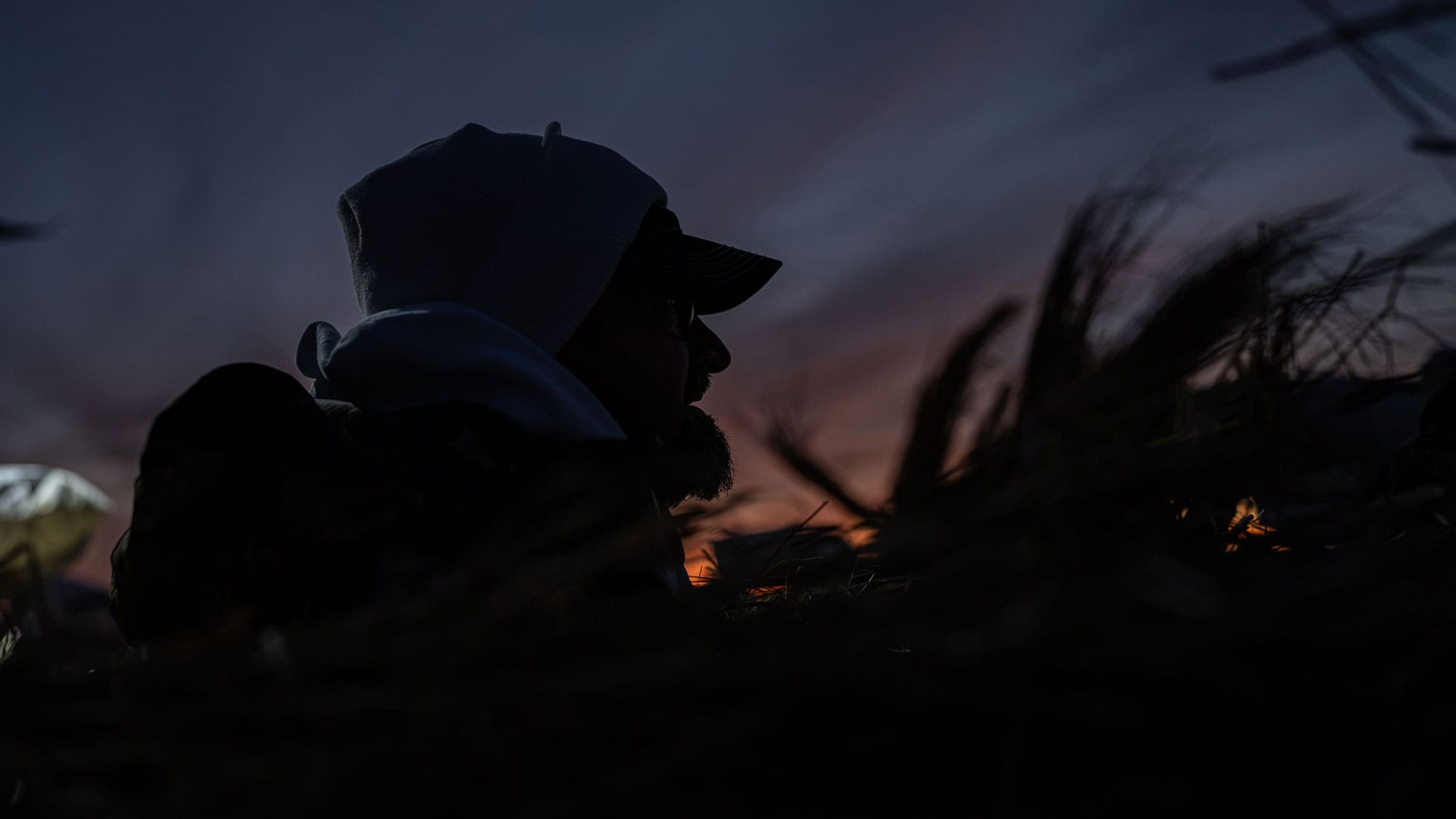 Hunter in white hidden in a brushed blind before sunrise